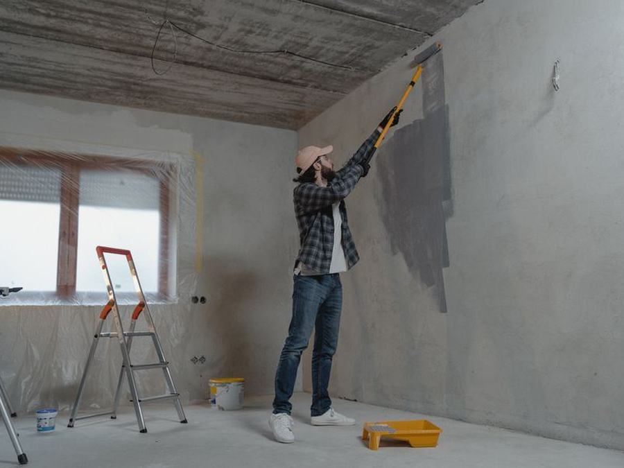 Maler bei Renovierungsarbeiten in einem Wohnraum
