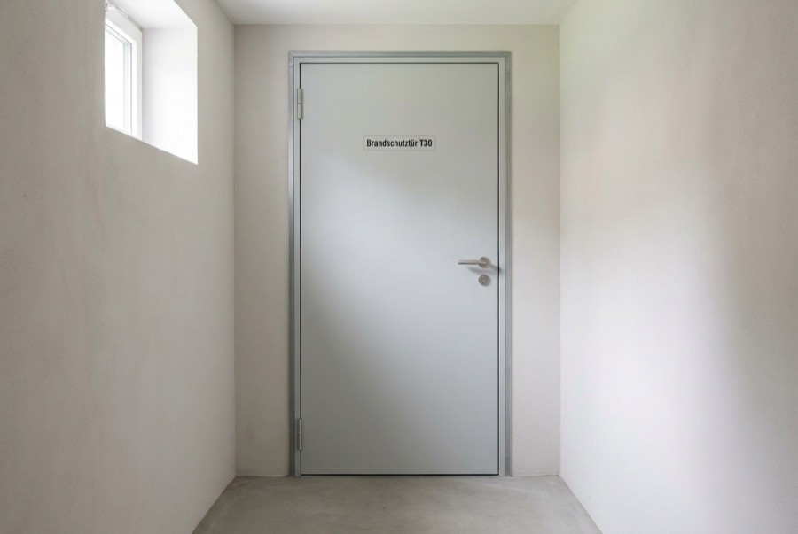 Graue Stahl-Brandschutztür in einem Kellerflur