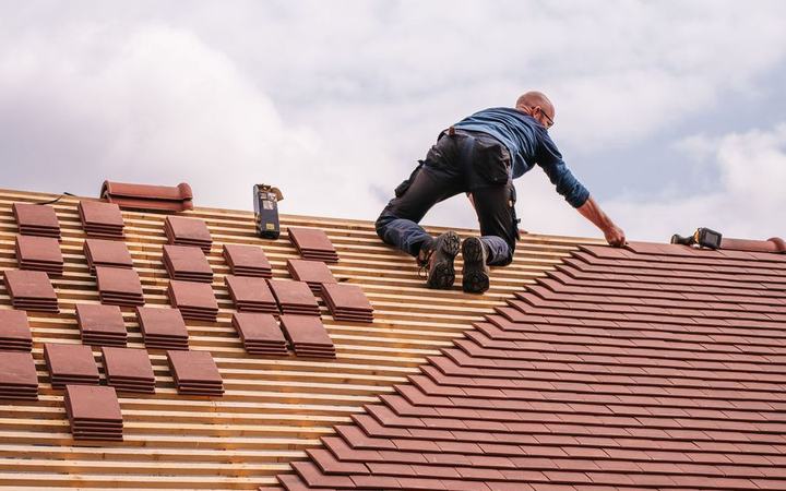 Dachdecker repariert ein Ziegeldach
