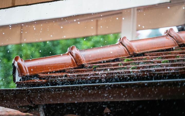 Regenwasser läuft über eine Dachrinne ab