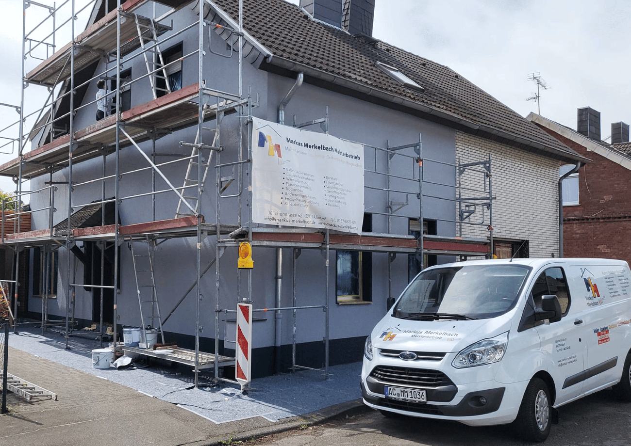 Firmenfahrzeug der Merkelbach Gruppe vor einer eingerüsteten Baustelle