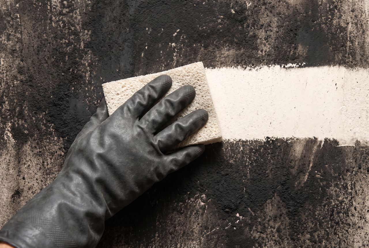 Ruß wird nach einem Brandschaden von einer Wand entfernt